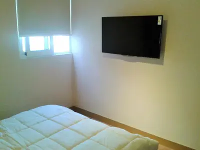 a bedroom with a bed and a flat screen tv on the wall at Peru Rent Apart com pe in Lima