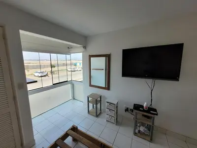 a living room with a flat screen tv on the wall at Departamento amplio en punta hermosa frente al mar in Punta Hermosa