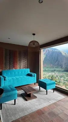 a living room with blue couches and a large window at Casa Catahuasi , Sacred Valley ,Urubamba,Cusco, Peru in Urubamba
