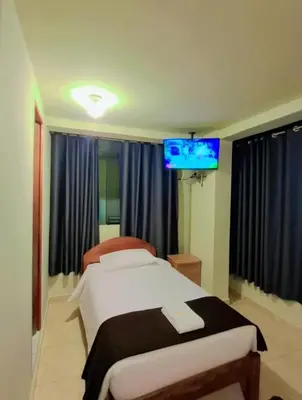 a bedroom with a bed and a flat screen tv at Kuntur House Machupicchu in Machu Picchu