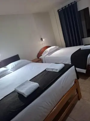 two beds in a hotel room with towels on them at Kuntur House Machupicchu in Machu Picchu