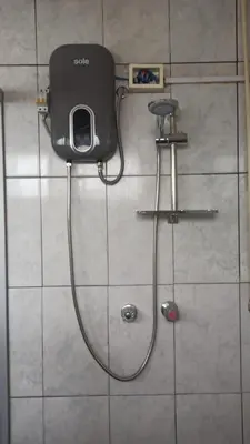 a shower with a hose attached to a wall at Depawanka habitacion amoblado in Huancayo