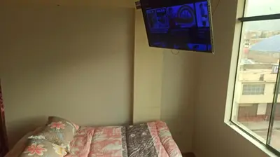 a bedroom with a bed and a tv on the wall at Depawanka habitacion amoblado in Huancayo