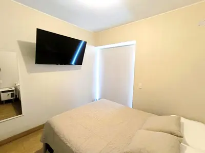 a bedroom with a bed and a flat screen tv on the wall at Departamento en Santa Catalina cerca a San Isidro in Lima
