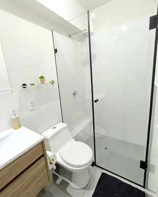 a white bathroom with a toilet and a shower at Departamento en Santa Catalina cerca a San Isidro in Lima