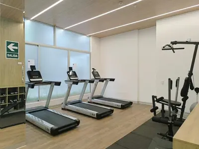 a gym with three treadmills and phones in a room at Departamento en Santa Catalina cerca a San Isidro in Lima
