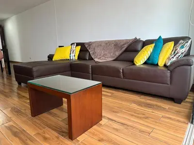 a brown couch with pillows and a table in a living room at El Derby 511 Aparts de 3 Dorm con Aire Acondicionado in Lima