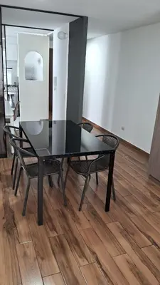 a black dining room table and chairs on a wooden floor at El Derby 511 Aparts de 3 Dorm con Aire Acondicionado in Lima