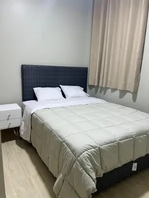 a bed with a blue headboard in a bedroom at Huacachina Lagoon House in Ica