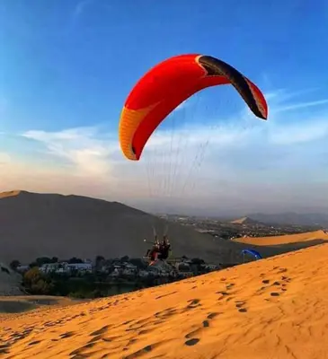 a person flying a parachute in the desert at Huacachina Lagoon House in Ica