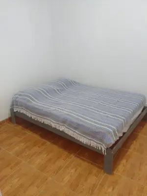 a bed with a blue blanket on a wooden floor at Casa, Playa el pasamayito sur de asia in Asia