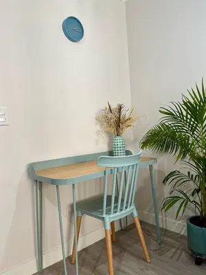 a table and a chair with a table and a clock at Art28 Studio Apartment in Lima