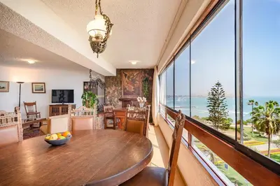 a dining room with a table and a view of the ocean at M701 Malecón View Apartment 3 BDR in Lima