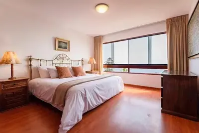 a bedroom with a bed and a large window at M701 Malecón View Apartment 3 BDR in Lima