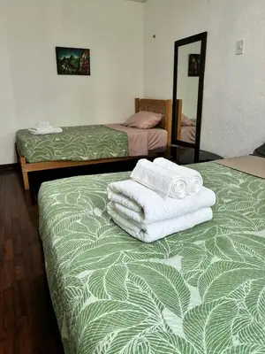 a room with two beds with towels on top of it at Green Love in Lima
