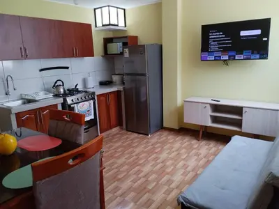 a kitchen with a refrigerator and a table in it at Habich Apartment in Lima