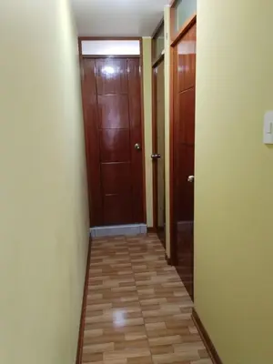 a hallway with two brown doors and a tile floor at Habich Apartment in Lima