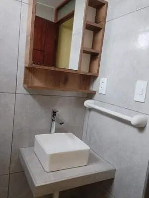 a bathroom with a white sink and a mirror at Habich Apartment in Lima