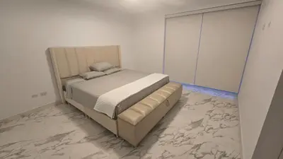 a bed in a bedroom with a marble floor at Casa de Playa de Estreno in Cerro Azul