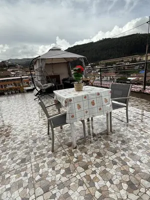a table and chairs on a patio with a tent at Chabela Host in Cusco