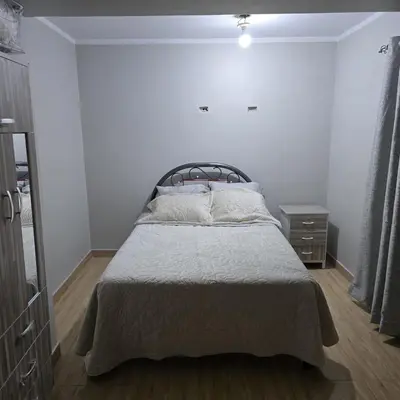 a white bedroom with a bed and a dresser at Departamento completo acogedor y con estacionamiento in Ayacucho