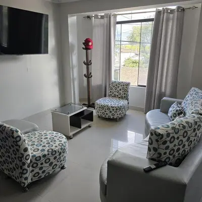 a living room with couches and chairs and a tv at Departamento completo acogedor y con estacionamiento in Ayacucho