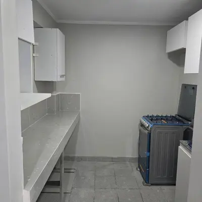 a small kitchen with a counter and a refrigerator at Departamento completo acogedor y con estacionamiento in Ayacucho