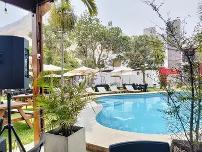 a swimming pool with chairs and umbrellas at Tambo II Hotel Campestre in Cieneguilla