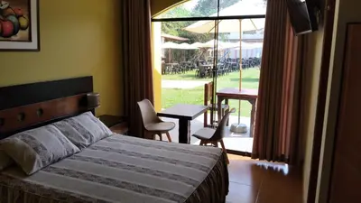 a bedroom with a bed and a table with chairs at Tambo II Hotel Campestre in Cieneguilla