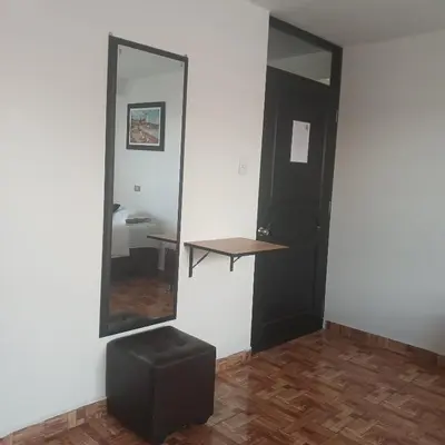 a mirror and a stool in a room at HOSTAl EGIPTO in Ayacucho
