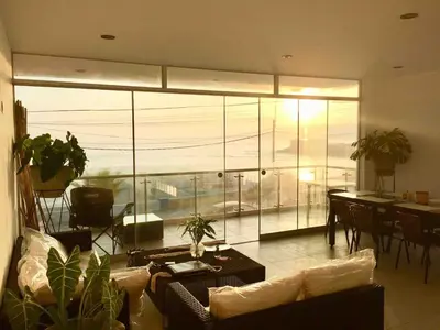 a living room with a large glass wall at Departamento San Bartolo, Excellent Location! in San Bartolo