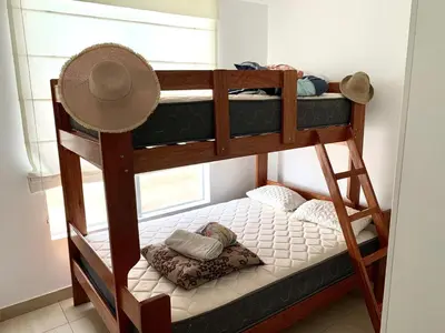 two bunk beds in a room with a hat at Departamento San Bartolo, Excellent Location! in San Bartolo
