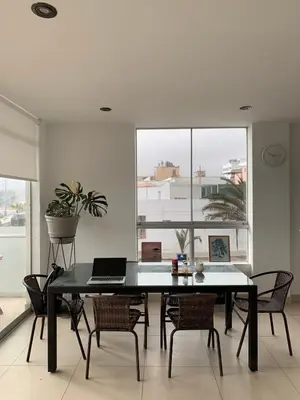 a dining room with a table with a laptop on it at Departamento San Bartolo, Excellent Location! in San Bartolo