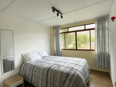 a bedroom with a bed and a window at La Casa del Valle - Huaripampa in Huaripampa