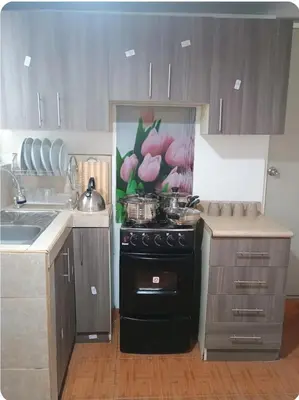 a kitchen with a black stove and a sink at Departamento Acogedor en Surco in Lima