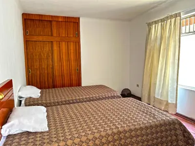 a hotel room with two beds and a window at Casa Molinera in Lima
