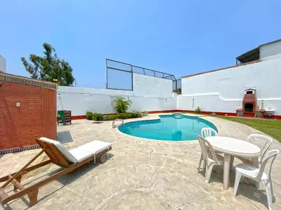 a patio with a table and chairs and a pool at Casa Molinera in Lima