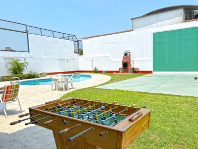 a wooden foosball table in a yard next to a pool at Casa Molinera in Lima