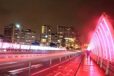 a city street with a lit up bridge at night at Chelovirock- Luxury Penthouse Great Location in Lima