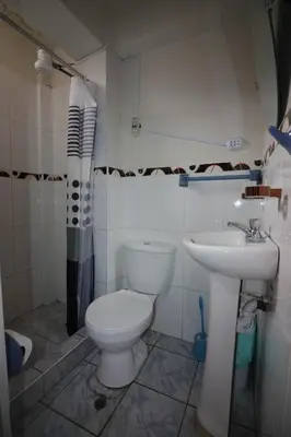 a bathroom with a toilet and a sink at Hospedaje Apu San Isidro in Urubamba