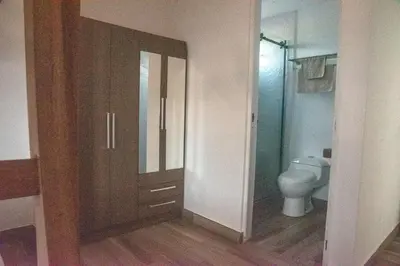a bathroom with a toilet and a wooden door at Zen Home & Relax - Chincha in Chincha Baja