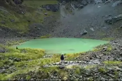 a person standing in front of a green lake at RiKCHARiY in Primavera