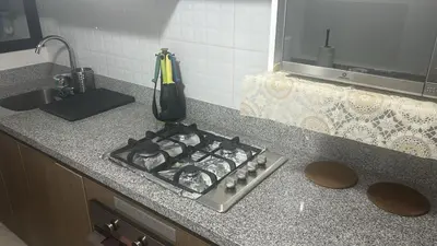 a kitchen counter with a stove and a sink at Luxury Aparment in San Isidro in Lima