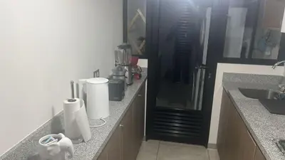 a kitchen with a counter with a sink and a refrigerator at Luxury Aparment in San Isidro in Lima