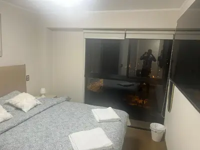 a bedroom with a bed and a window with a camera at Luxury Aparment in San Isidro in Lima