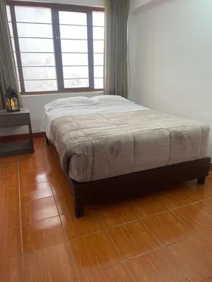 a bed in a bedroom with a wooden floor at Quechuas in Cusco