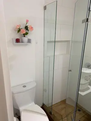 a bathroom with a toilet and a glass shower at Apartment Rosi Beach & Pool Punta Hermosa in Punta Hermosa