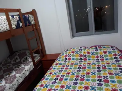 a bedroom with a bed with a quilt on it at Apartment Rosi Beach & Pool Punta Hermosa in Punta Hermosa
