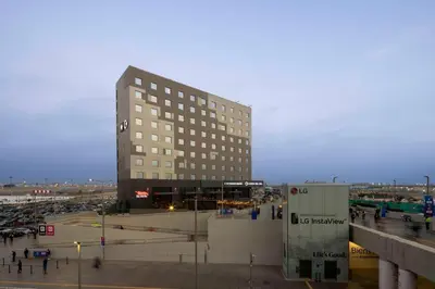 a tall building in a city with a parking lot at Wyndham Grand Costa Del Sol Lima Airport in Lima