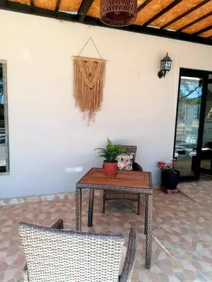 a patio with a table and chairs and a wall at Hotel Sol de Ocucaje #4 in Ica